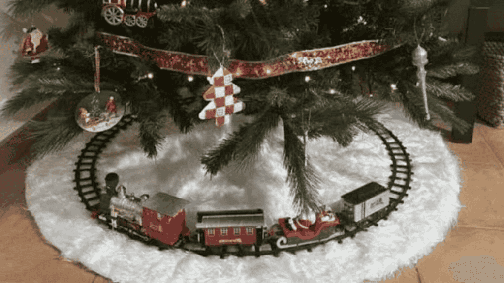 Tren de navidad para árbol instalado en el pie sobre faldón blanco decorativo